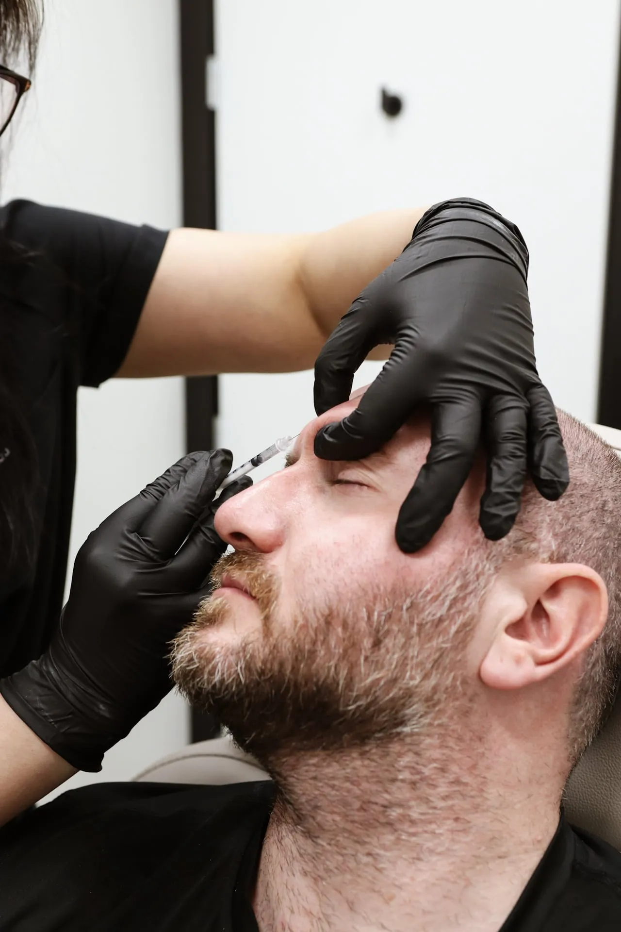 A male patient receives a neuromodulator injection in his brow